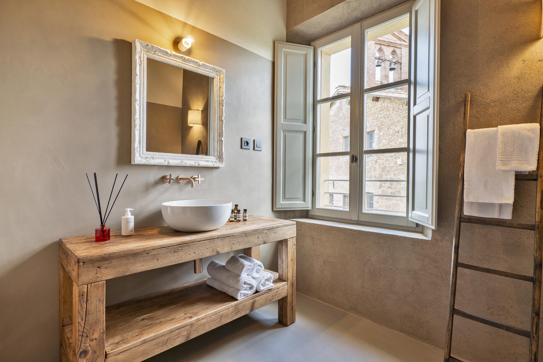 Il bagno con lavabo in pietra su consolle di legno antico