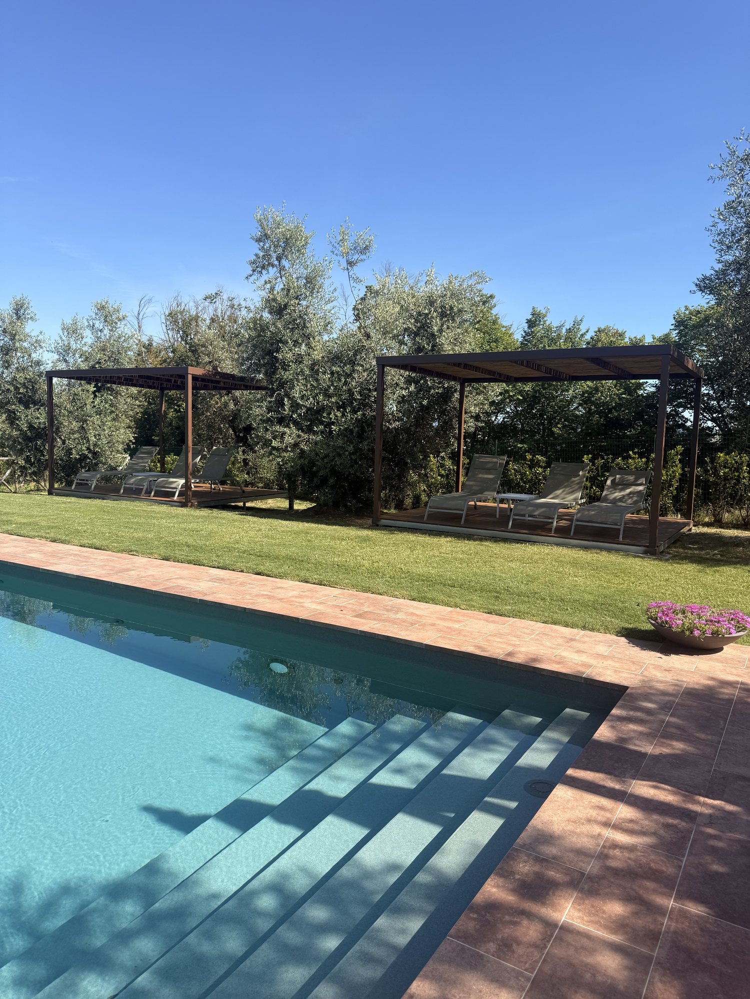 Le pergole con i lettini accanto alla piscina