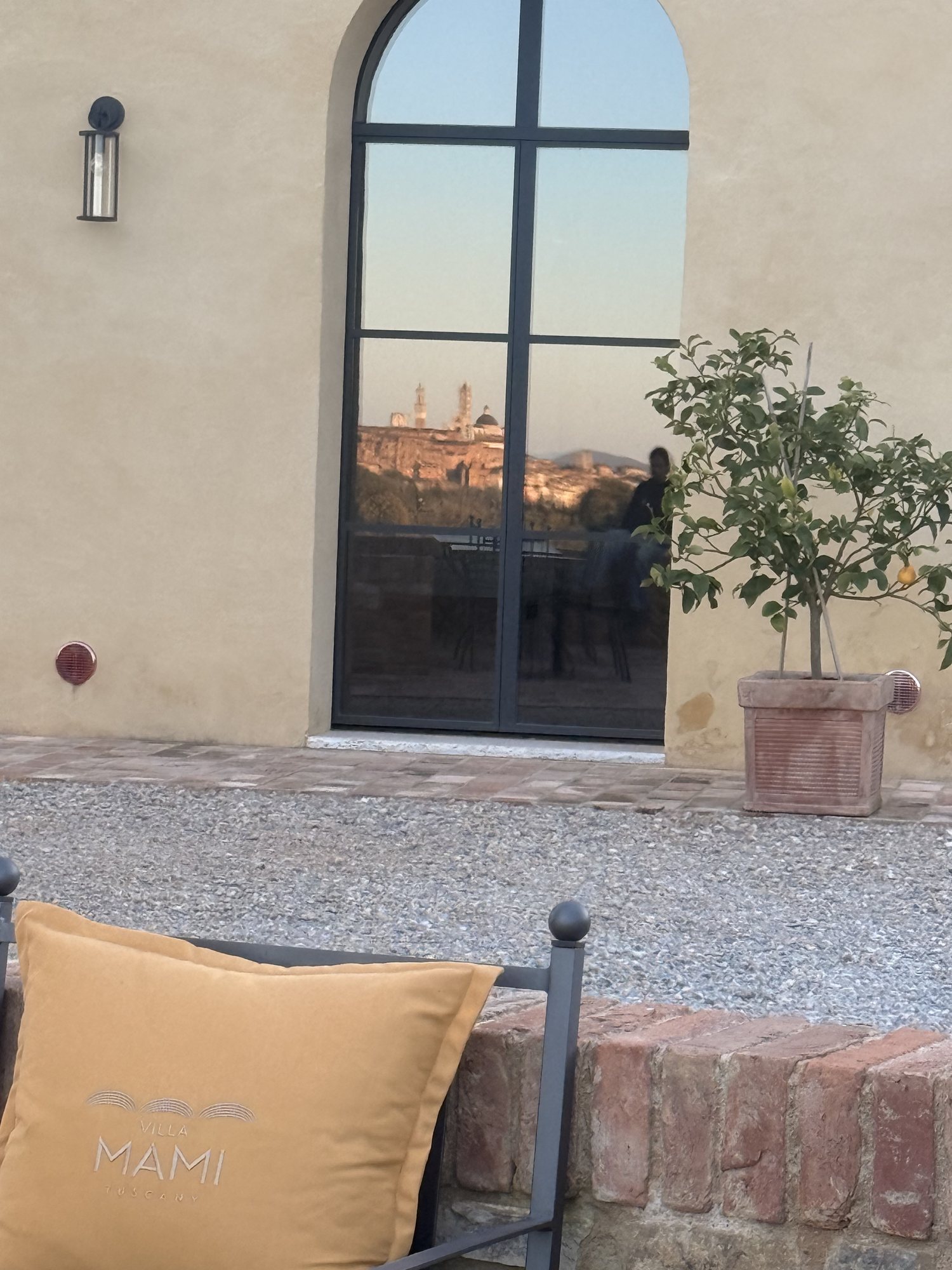 Il cuscino ricamato Villa Mami e Siena riflessa nella vetrata ad arco