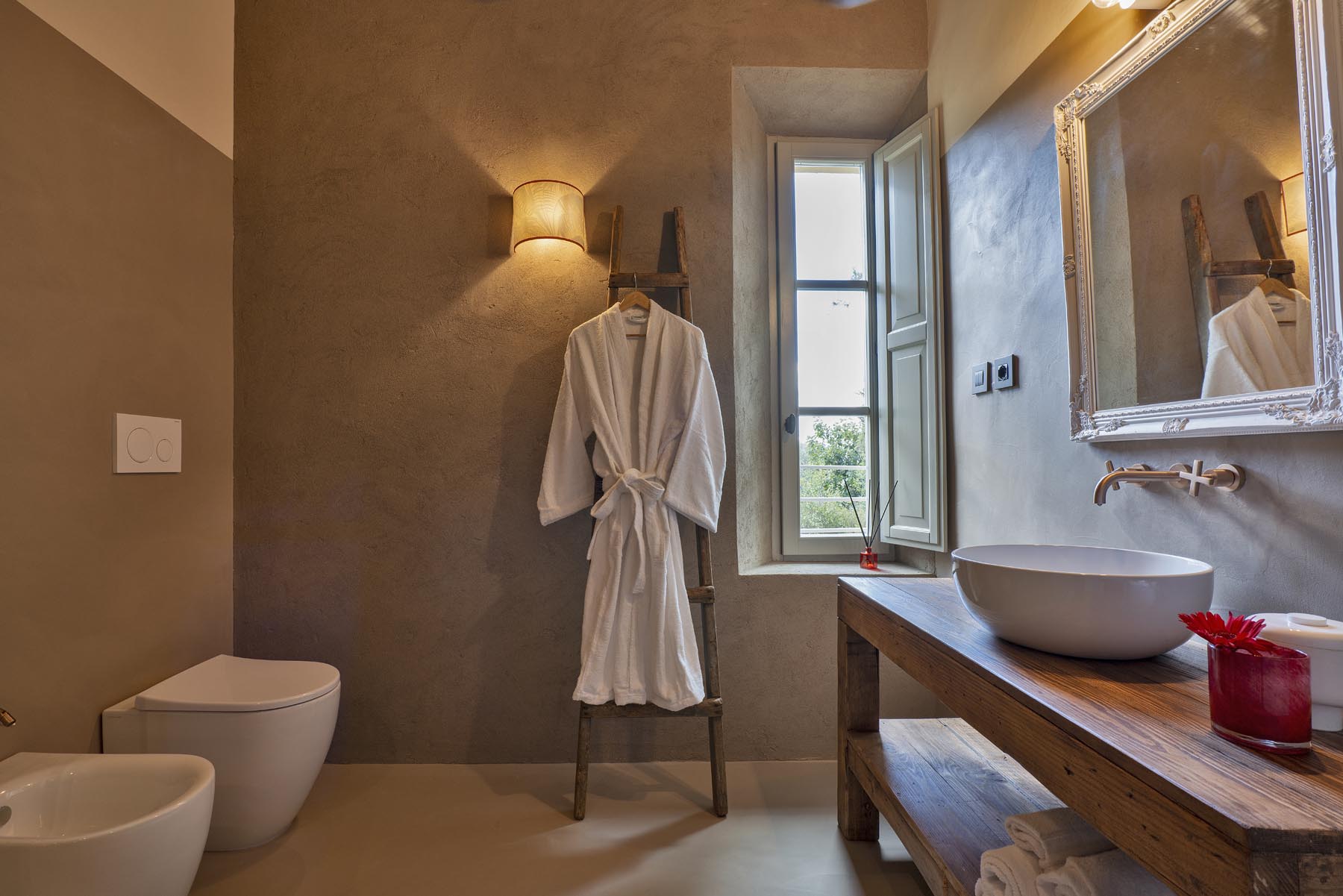 Il bagno con specchio dorato e accappatoi